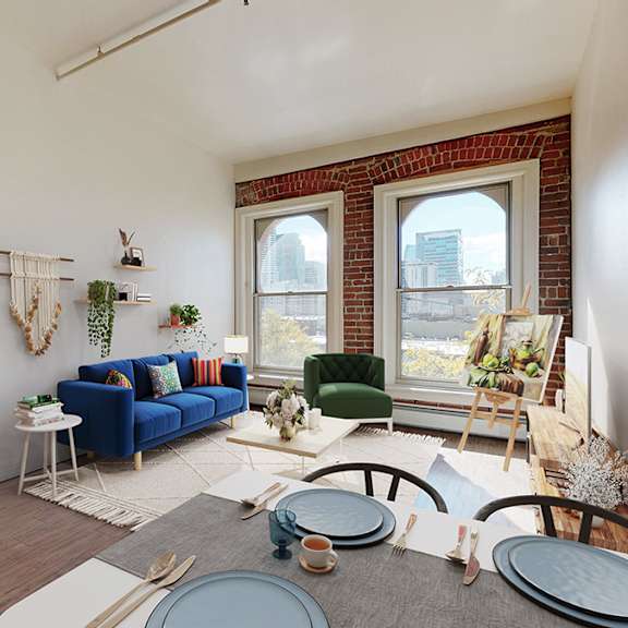a living room with a blue couch and 2 large floor-to-ceiling windows showing downtown denver views.