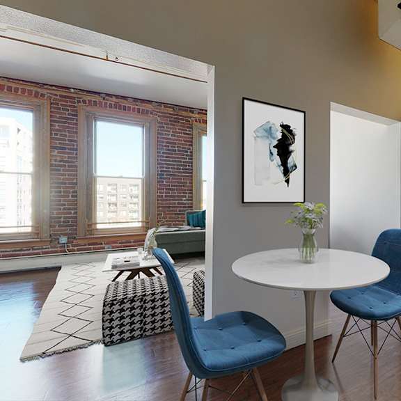 a galley kitchen next to a small dining table and chairs