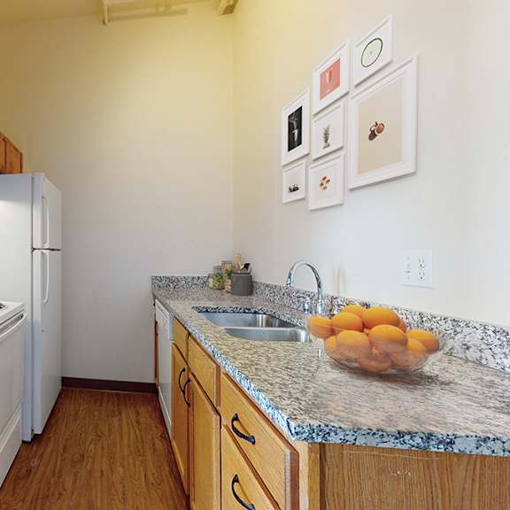 a kitchen with a white fridge and wooden cabinets.