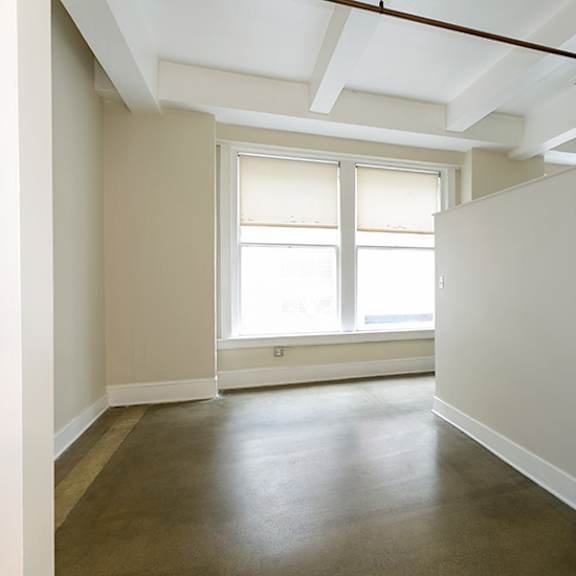 a room with a window and a brown floor.