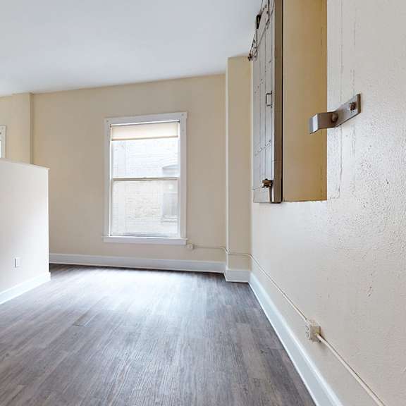 a room with a window and wooden flooring.
