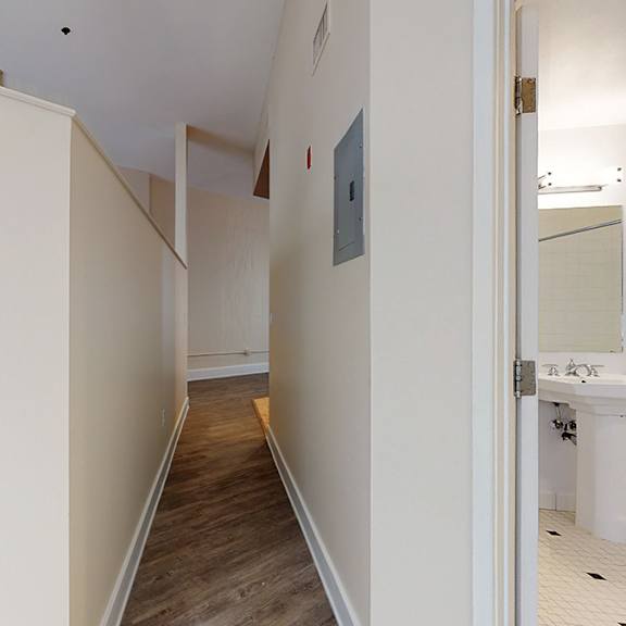 a long hallway with a door on the right.