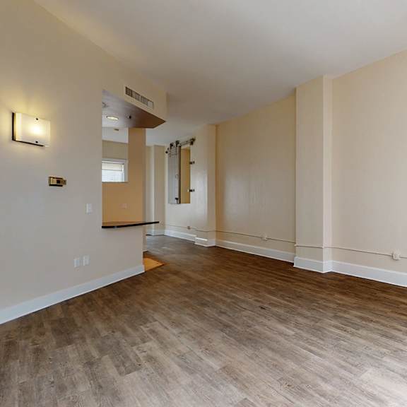 a room with wooden flooring and white walls.
