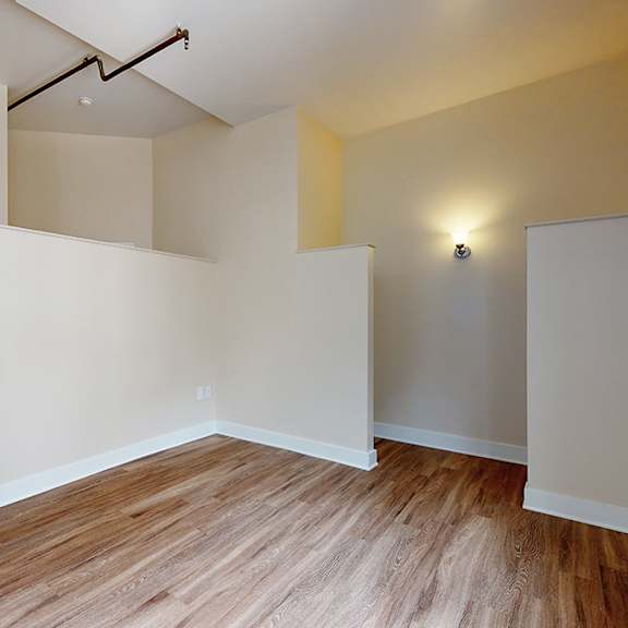 a room with wooden flooring and white walls.