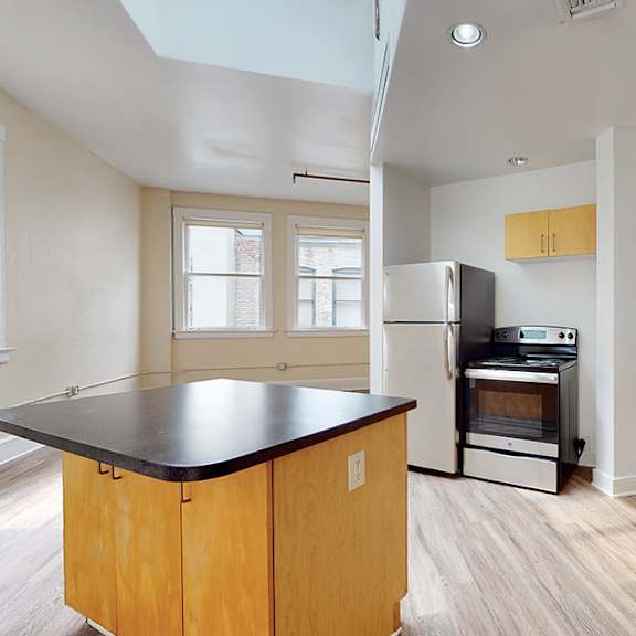 a kitchen with wooden cabinets and a black countertop.