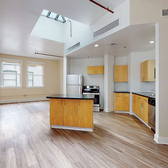 a kitchen with wooden cabinets and a skylight.