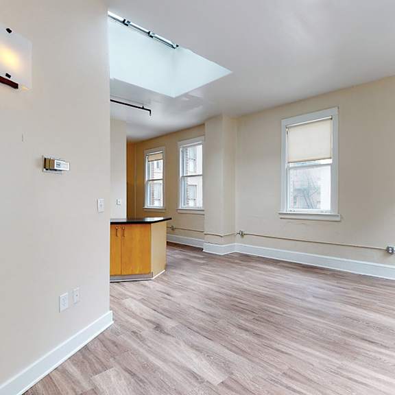 a room with wooden flooring and a skylight.