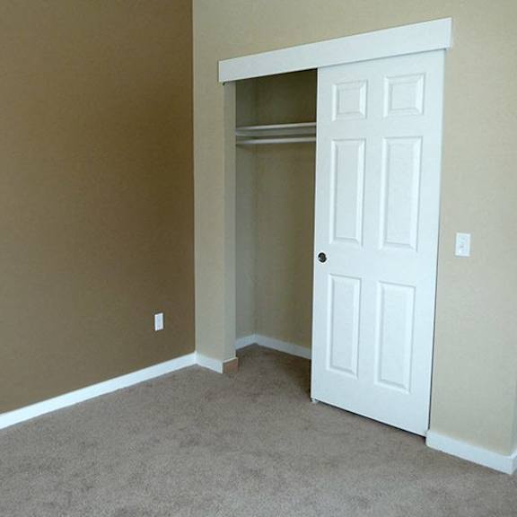a room with a white door and carpeted floor.