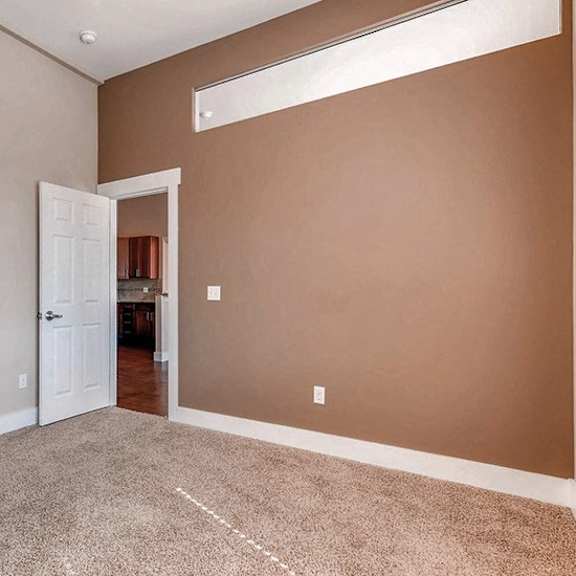 a room with a carpeted floor and a white door.