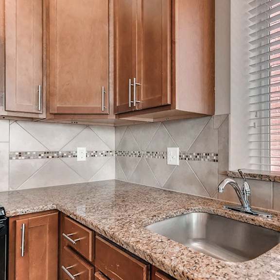 a kitchen with a sink and wooden cabinets.
