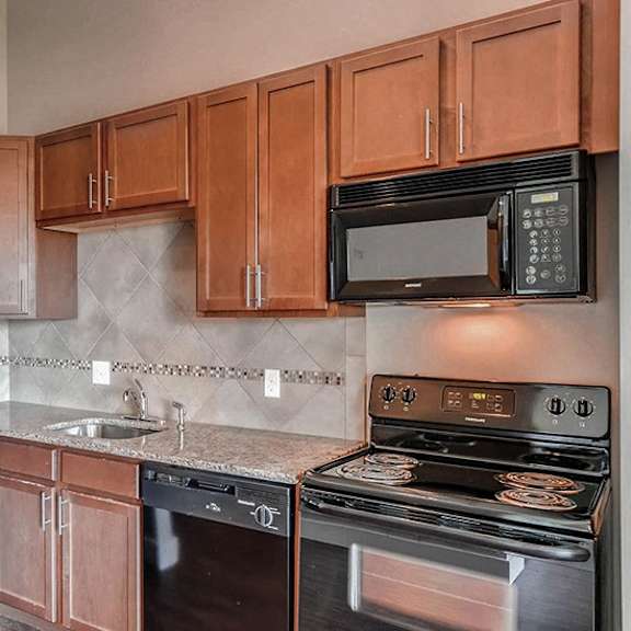 a kitchen with black appliances and wooden cabinets.