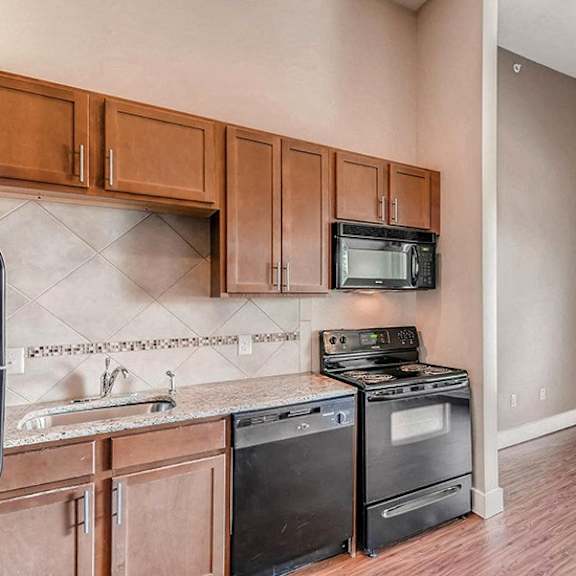 a kitchen with wooden cabinets and a black stove top oven.