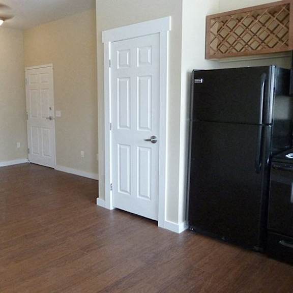 a kitchen with a black fridge and white doors.