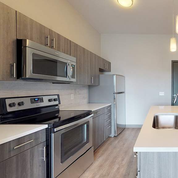 a kitchen with a stove, oven, microwave, and refrigerator.