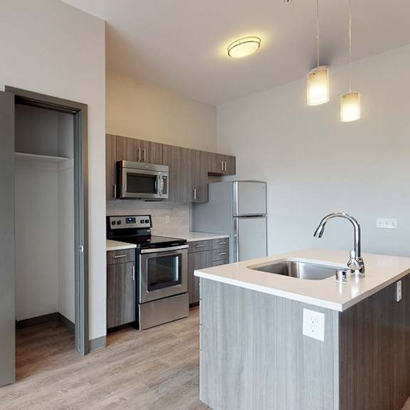 a kitchen with a sink, stove, and refrigerator.