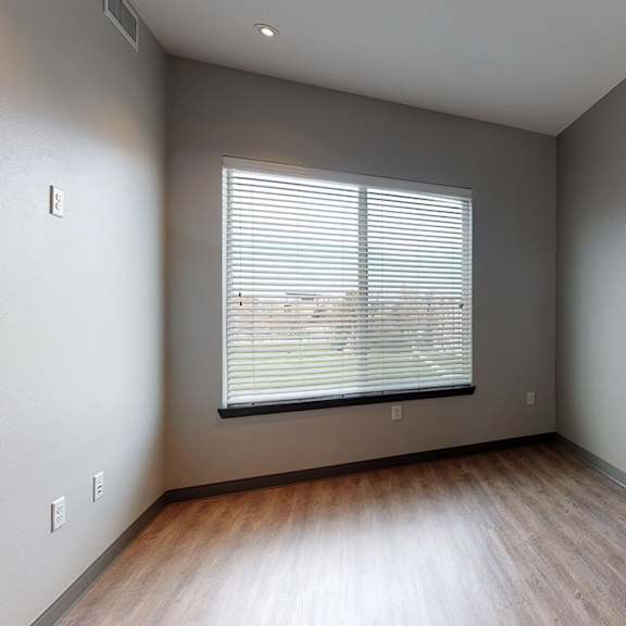a room with a window and wooden flooring.