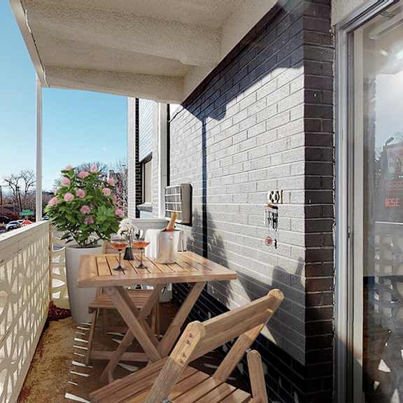 a balcony with a table and chairs overlooking a street.