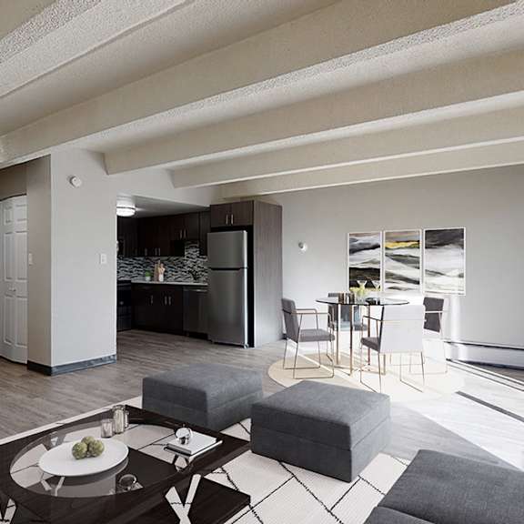 a modern living room with a grey sofa, a coffee table, and a potted plant.