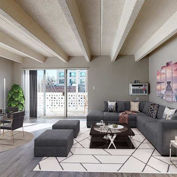 a modern living room with a grey sofa, a coffee table, and a large window.