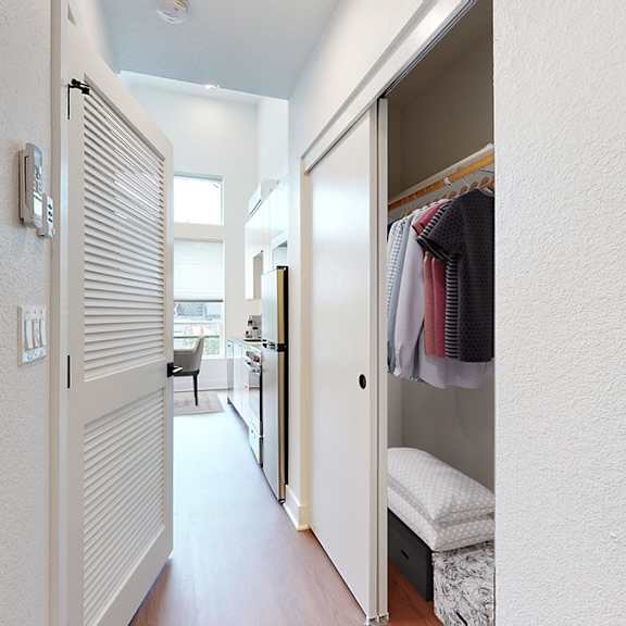 a hallway with a white door and a white wall.