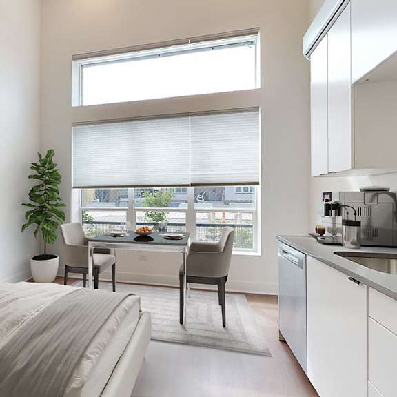 a bedroom with a large bed and a kitchen area.
