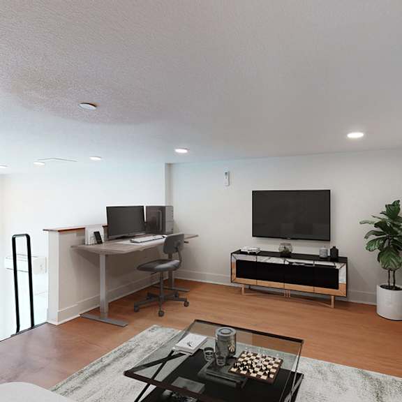 a modern living room with a flat screen tv and a desk with a computer.