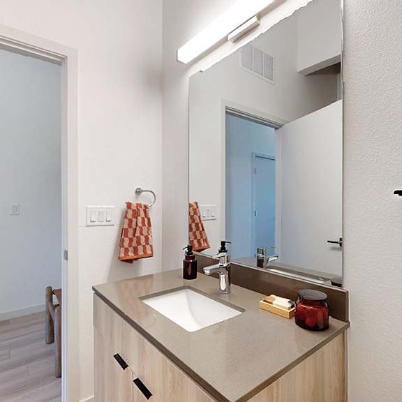 a bathroom with a sink, mirror, and towel rack.
