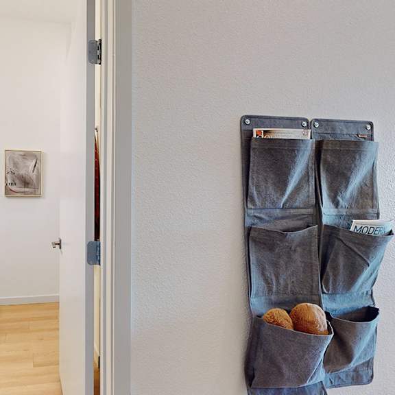 a pair of jeans hanging on a wall with pockets filled with snacks.