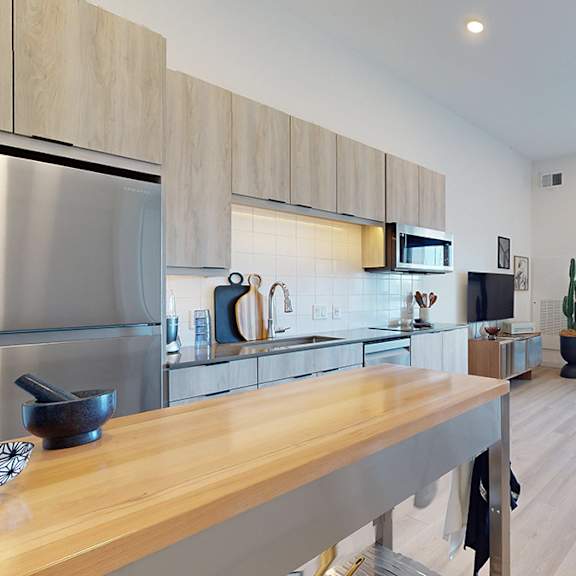 a modern kitchen with wooden cabinets and a large island.