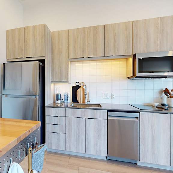 a modern kitchen with a wooden countertop and stainless steel appliances.