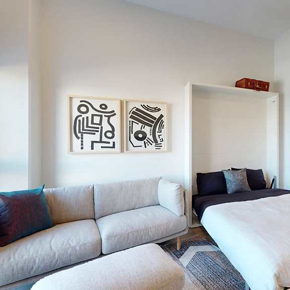 a bedroom with a bed, a couch, and a painting on the wall.