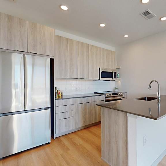 a modern kitchen with a refrigerator, sink, and countertop.