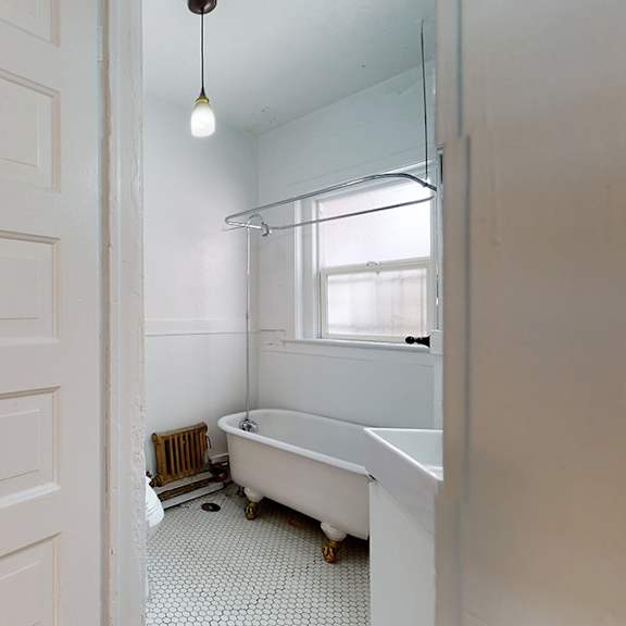 a white bathroom with a tub, toilet, and sink.