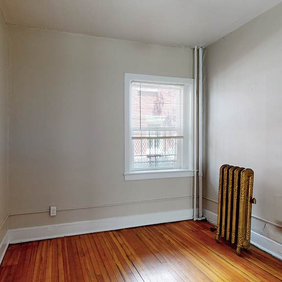 a room with a window and a radiator on the floor.