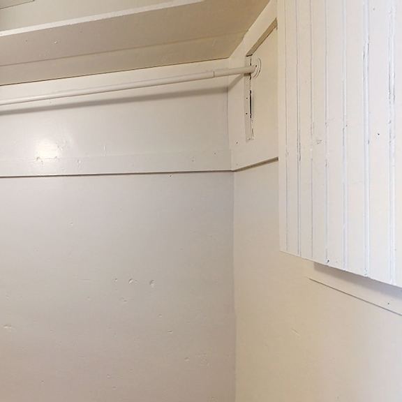 a white room with a pipe on the ceiling.
