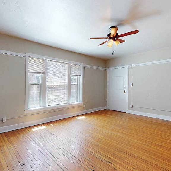 a room with a ceiling fan and a radiator on the floor.