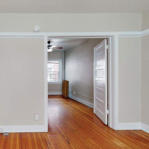 a room with a wooden floor and white walls.
