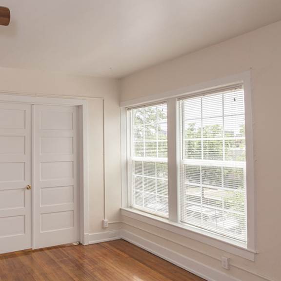 a room with a ceiling fan and a window with blinds.