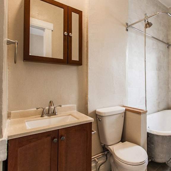 a bathroom with a toilet, sink, and tub.