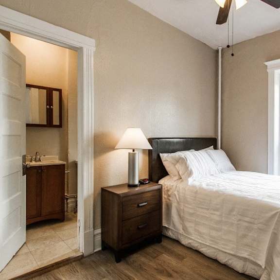 a bedroom with a bed, nightstand, and a window.
