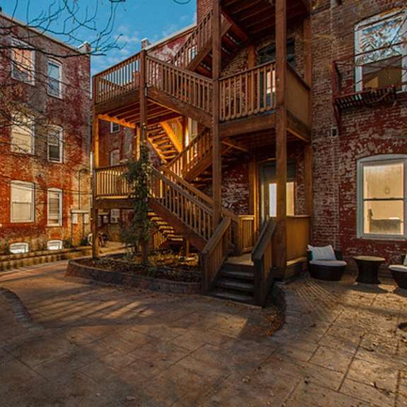 a courtyard with a staircase and a tree.