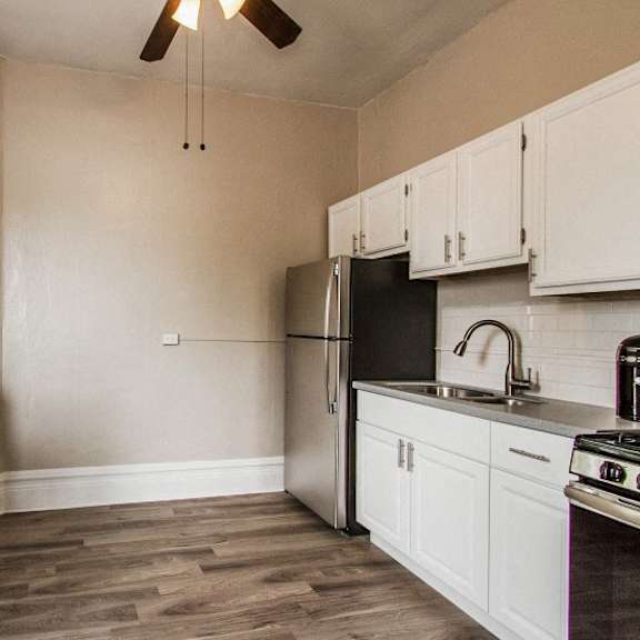 a kitchen with a table and chairs by a window.