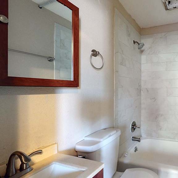 a white bathroom with a sink, toilet, and tub.