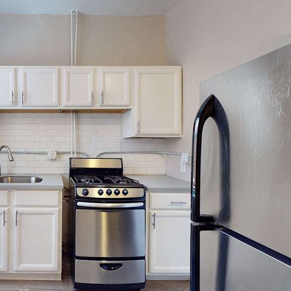 a modern kitchen with white cabinets and stainless steel appliances.