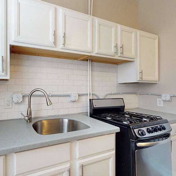 a kitchen with white cabinets and a black stove.