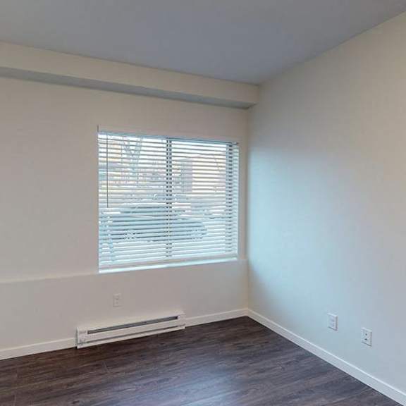 a room with a window and a heater on the floor.