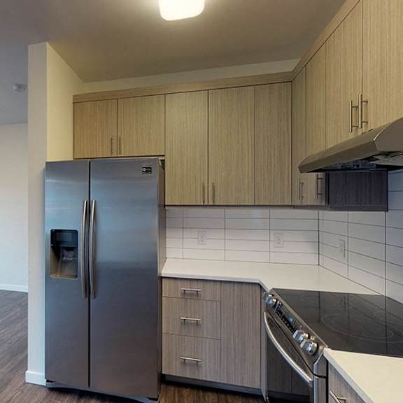 a kitchen with a stainless steel refrigerator and wooden cabinets.