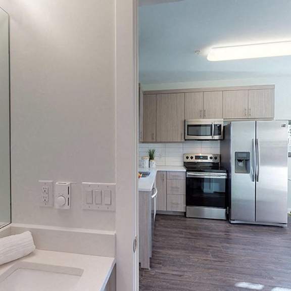 a modern kitchen with a white countertop and stainless steel appliances.
