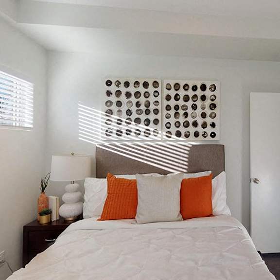 a bedroom with a bed, pillows, and a decorative wall panel.