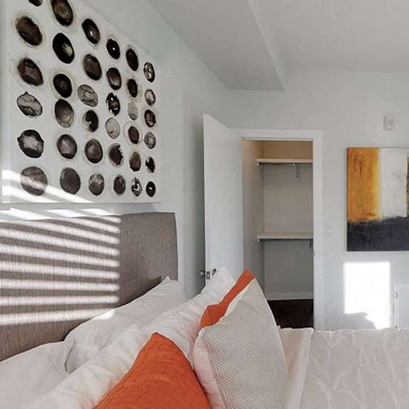 a bedroom with a bed and a painting on the wall.